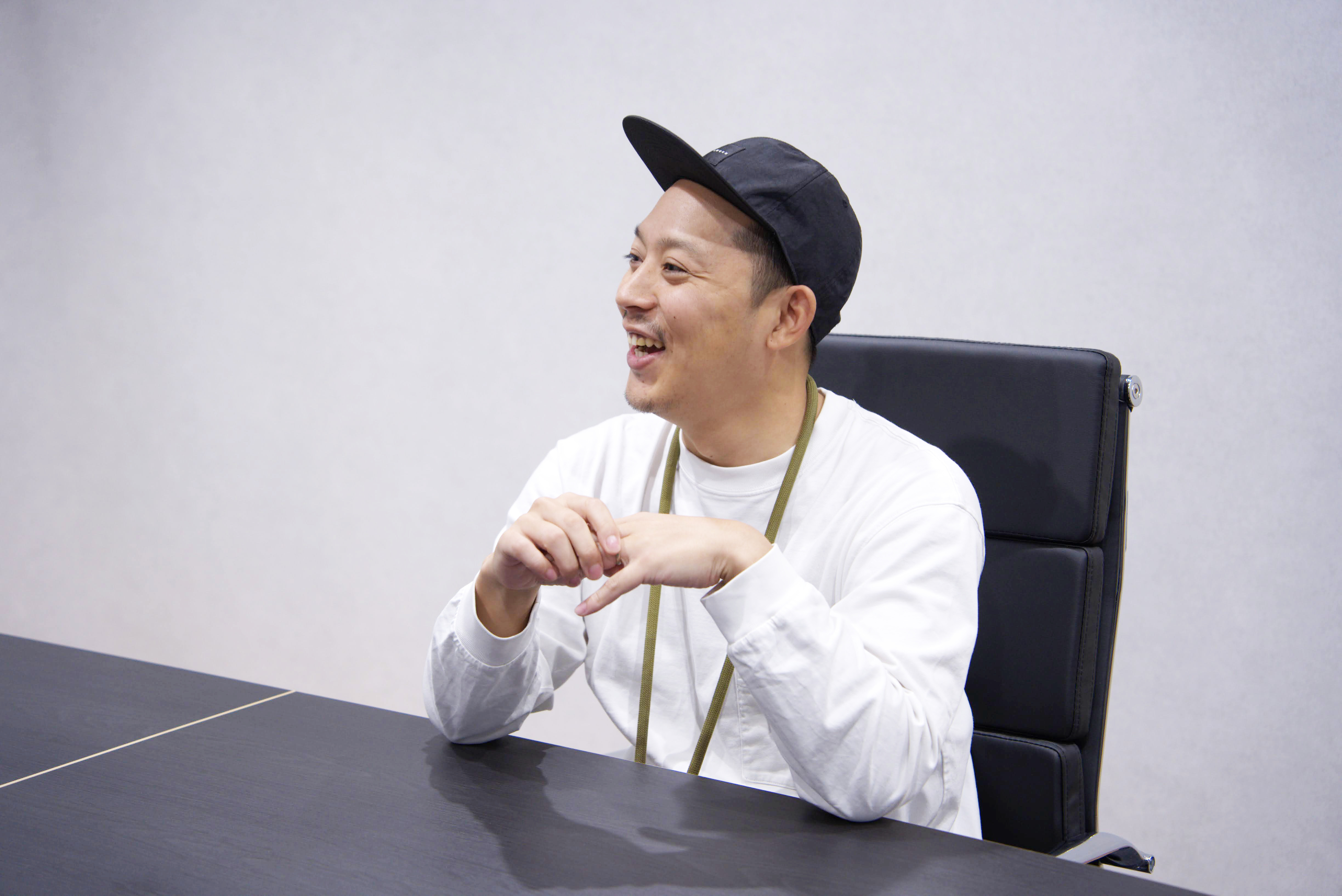 白いTシャツを着た担当者が座っている